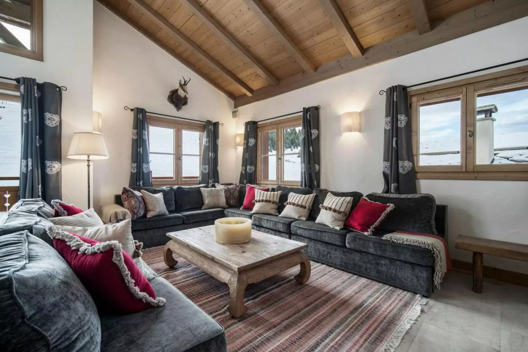A living room with dark seating arranged around a low wooden coffee table.
