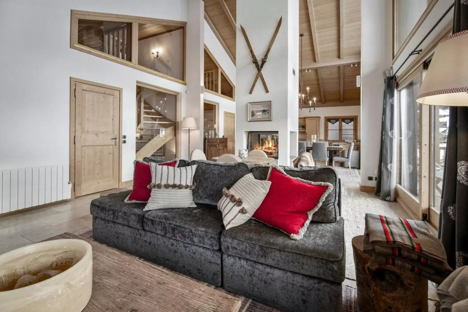 A spacious living room with a dark sofa and a fireplace behind it.