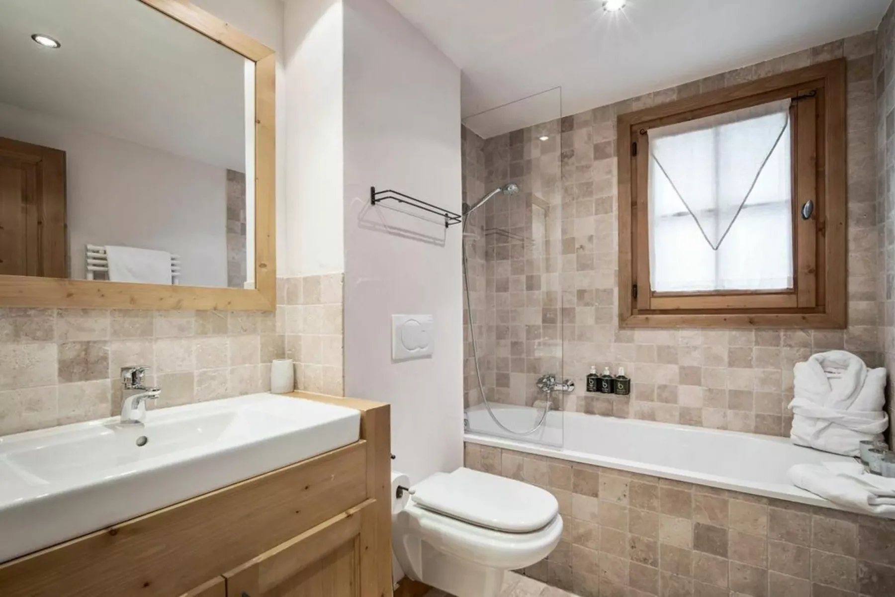 A tiled bathroom with a bathtub, sink, and toilet.