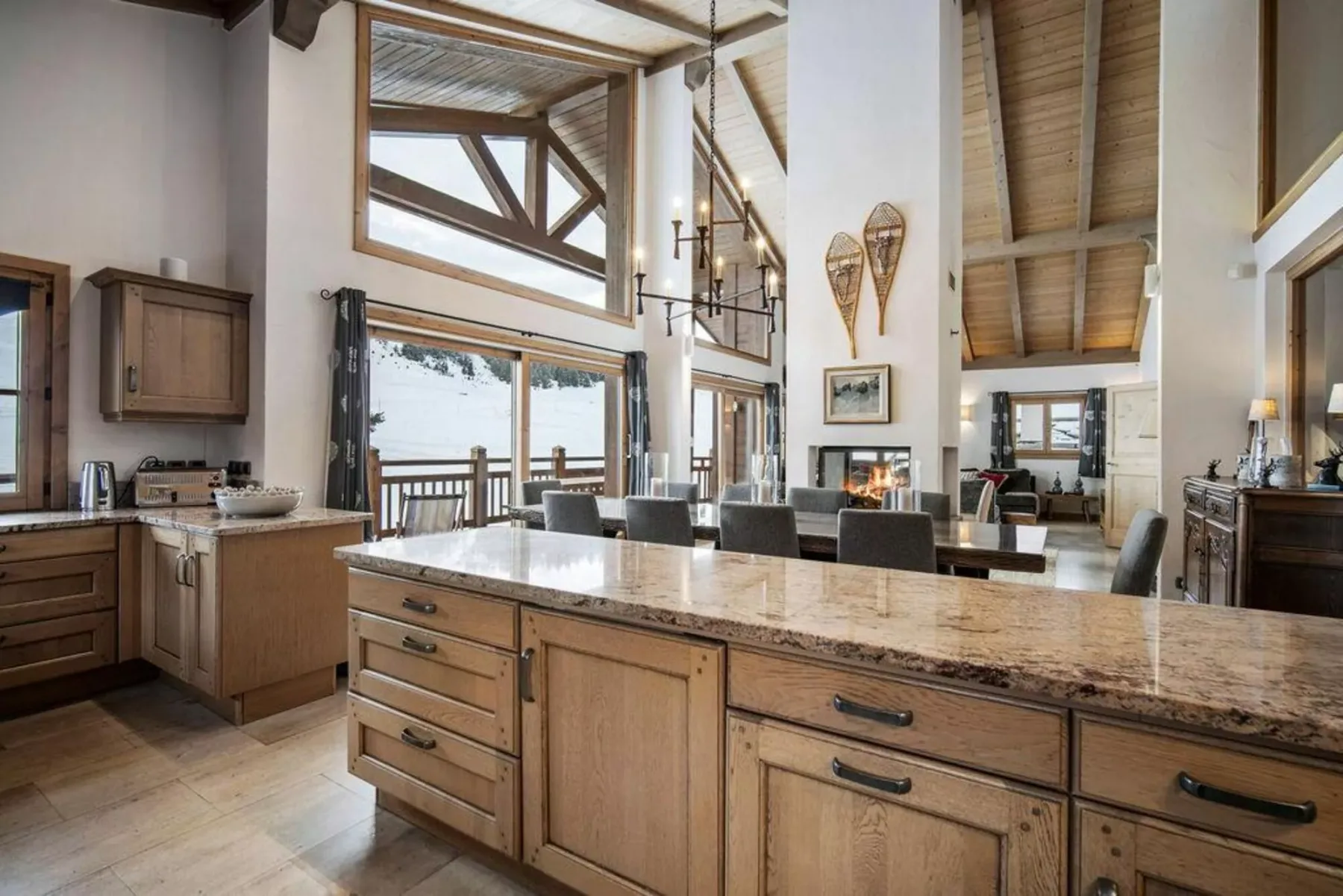 A spacious kitchen and dining area with a large island and exposed timber ceiling.