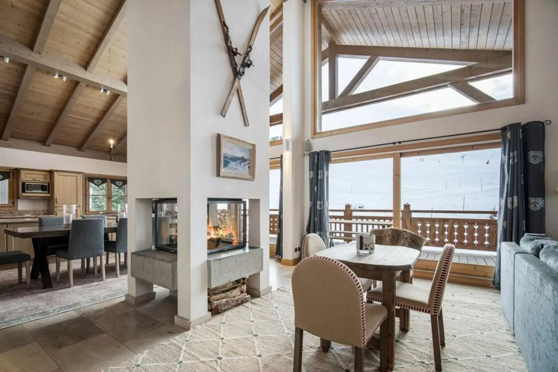 A spacious living and dining area with a fireplace and large windows.