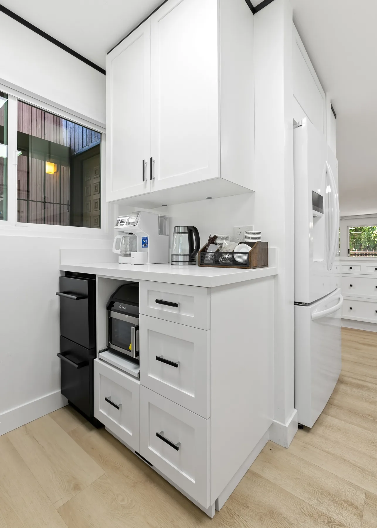 Una cocina blanca y luminosa con electrodomésticos empotrados y una encimera.