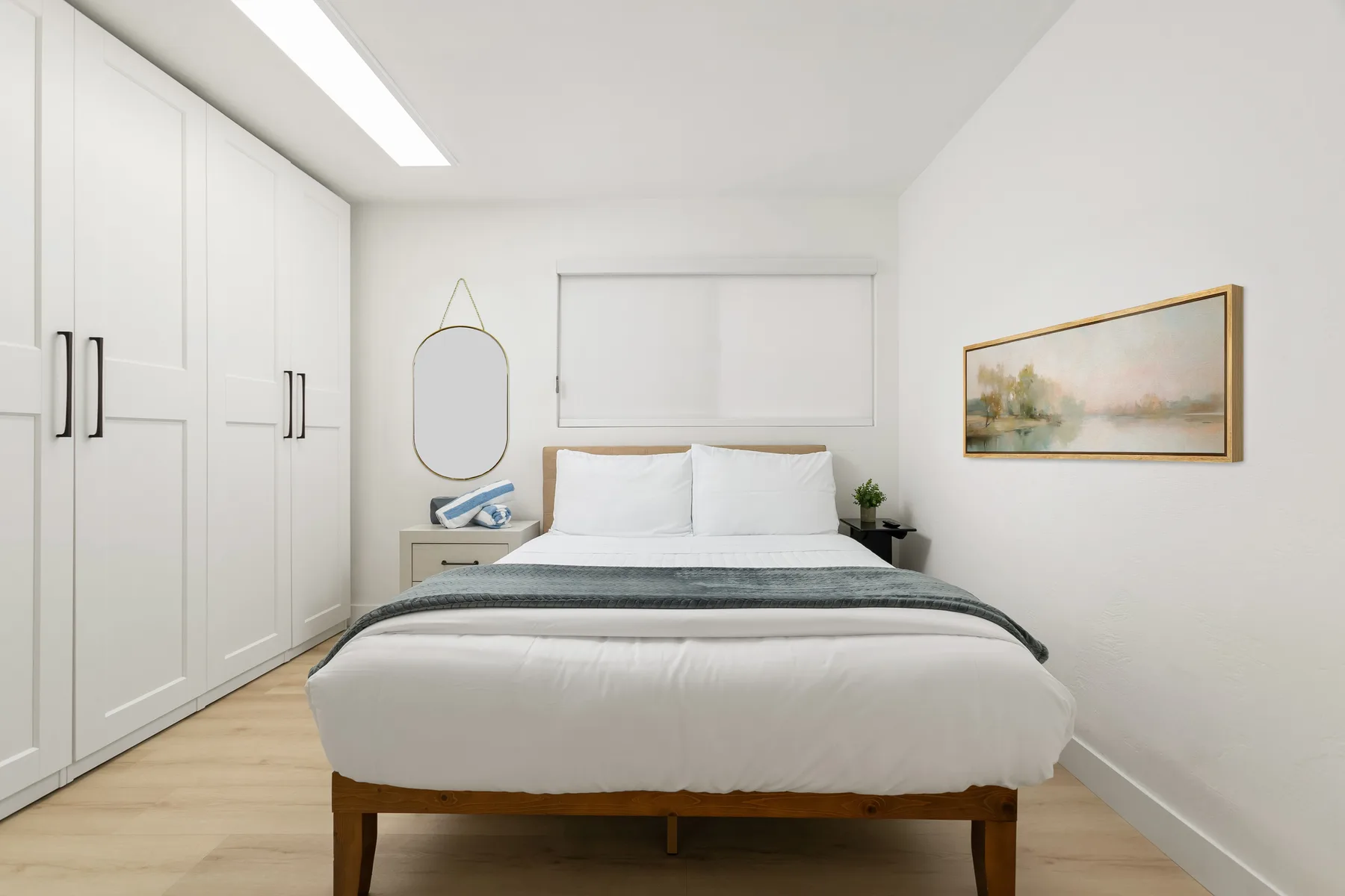 Un dormitorio luminoso con una cama bien tendida y armarios empotrados.