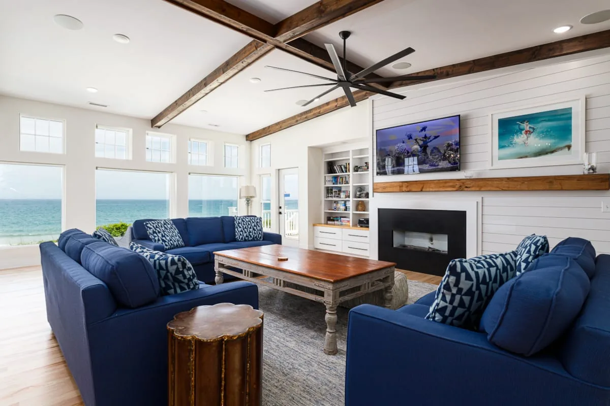 A bright living room with blue seating arranged around a wooden coffee table.