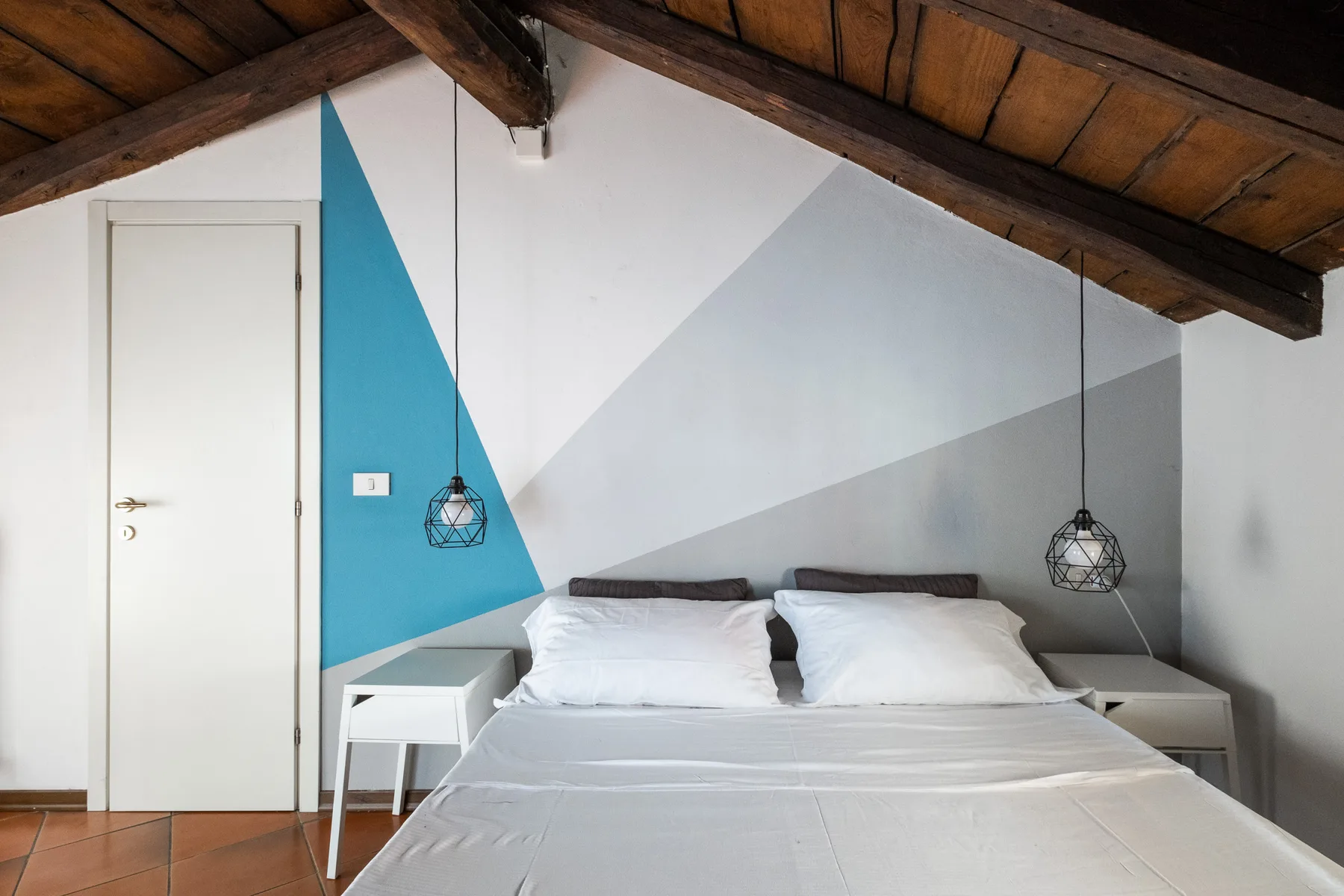 Un dormitorio con una cama bajo un techo inclinado de madera.