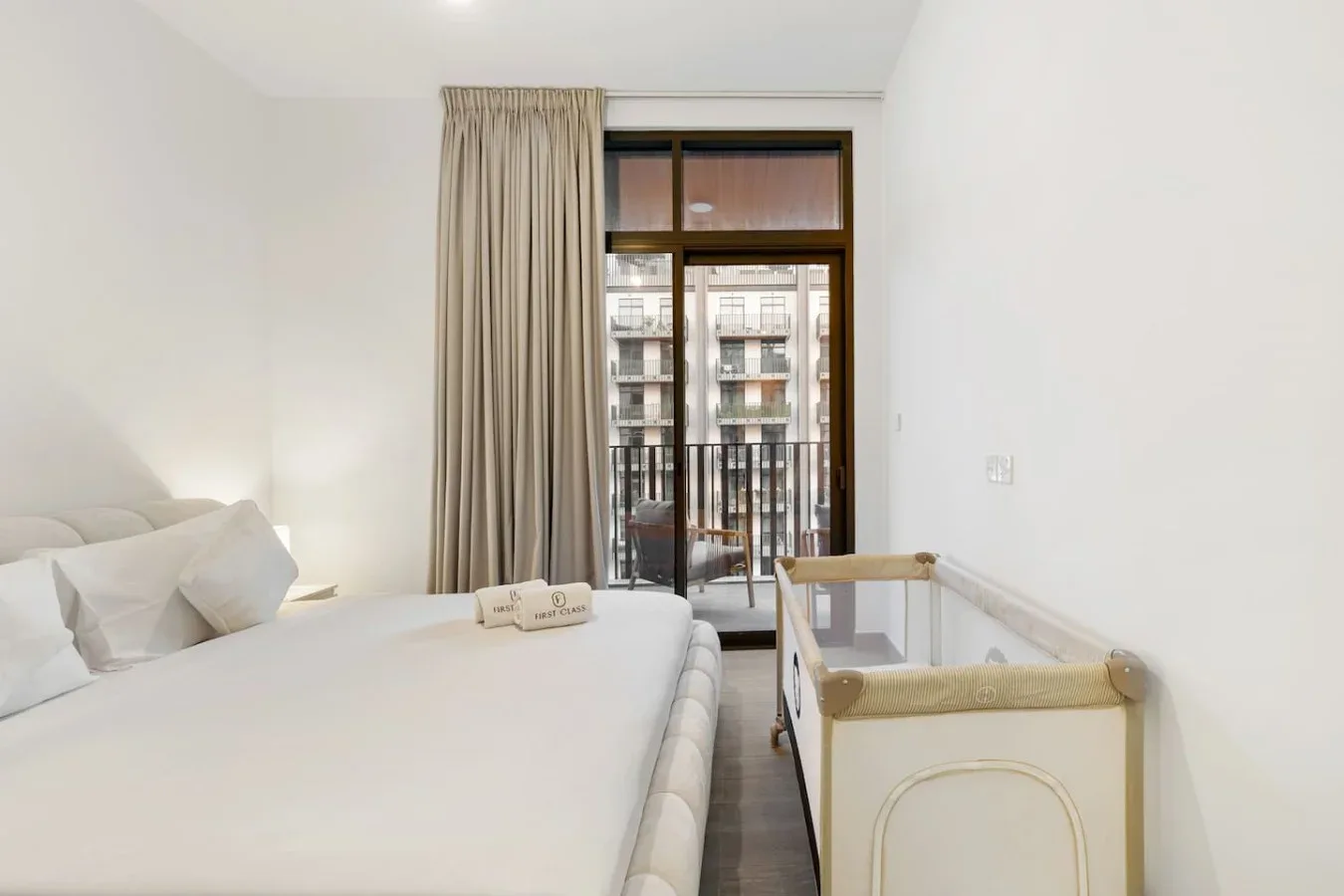 A bright bedroom with a bed beside a window and glass door.