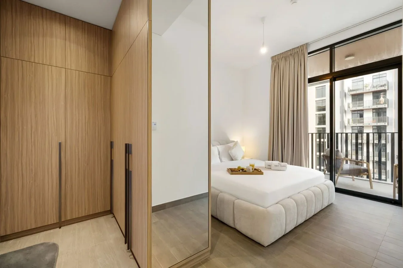 A bedroom with a neatly made bed beside a large window.