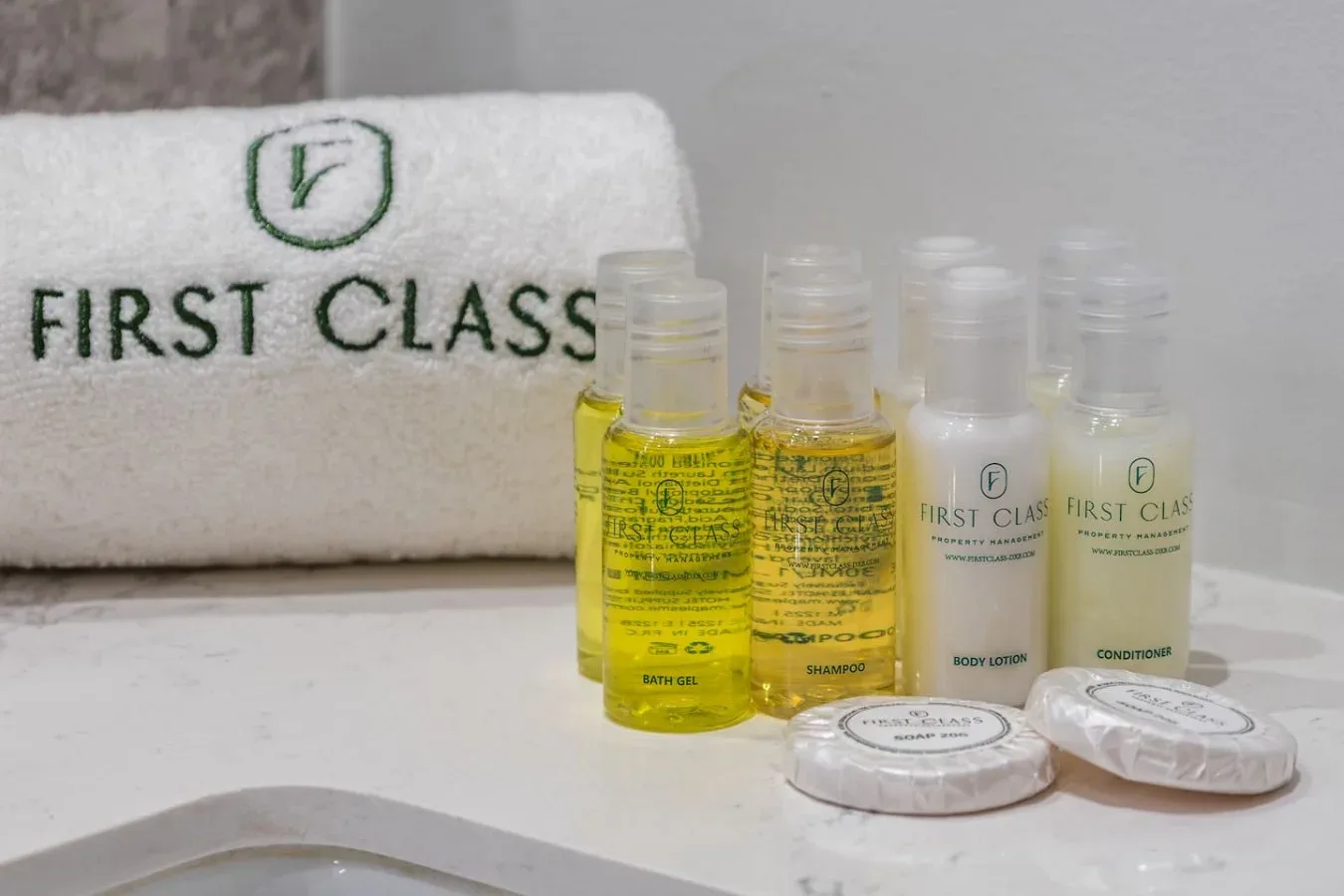 Hotel toiletries, including small bottles and wrapped soap, sit beside a branded towel.