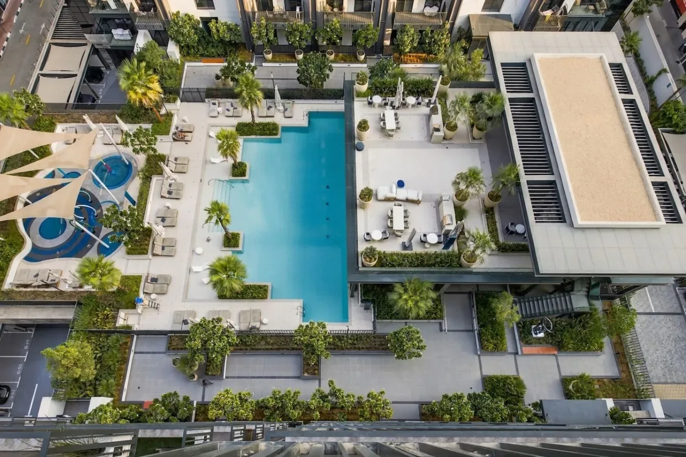 An elevated view of a swimming pool and landscaped outdoor seating areas.