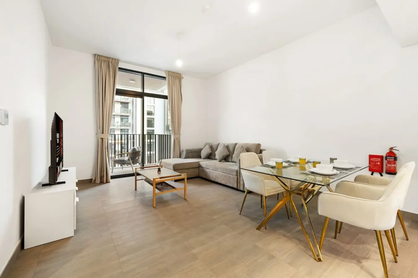 Bright living room with a sectional seating area, coffee table, and dining table.