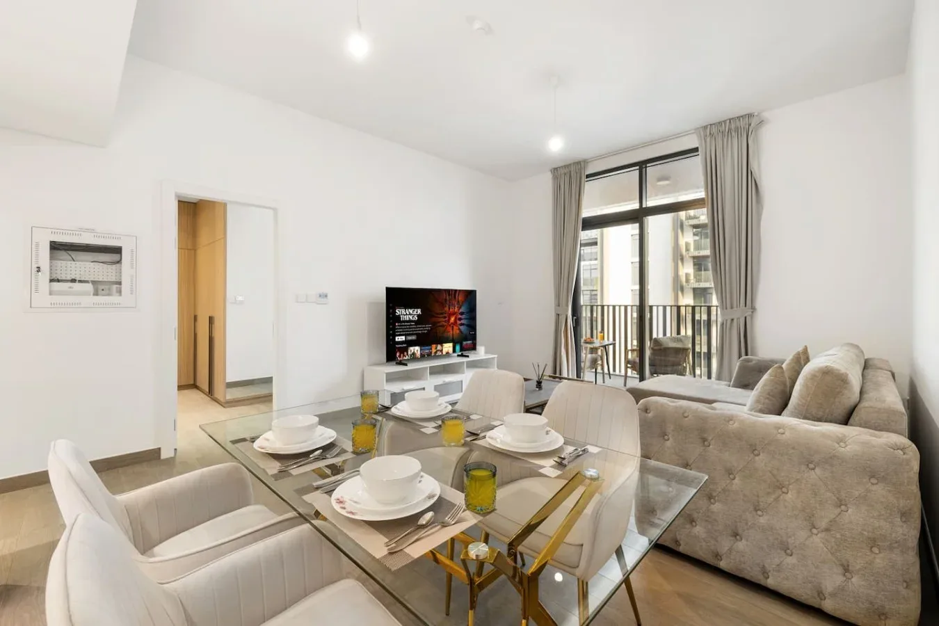 A bright living and dining area with a glass dining table and seating.