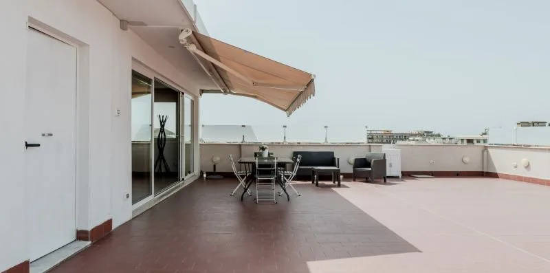 A rooftop terrace with outdoor seating and a retractable awning.
