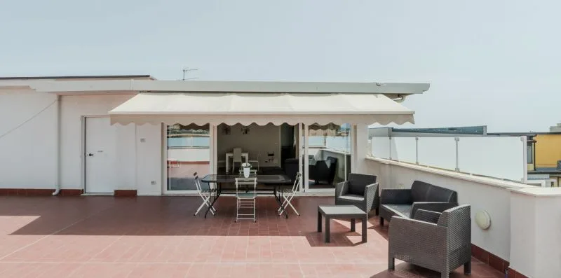 A rooftop terrace with outdoor seating and a shaded dining area.