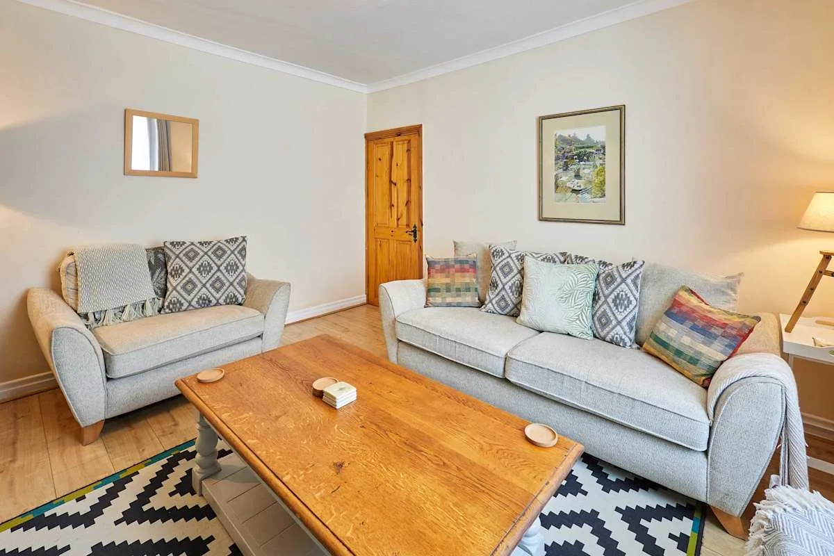 A living room with light-colored seating around a wooden coffee table.