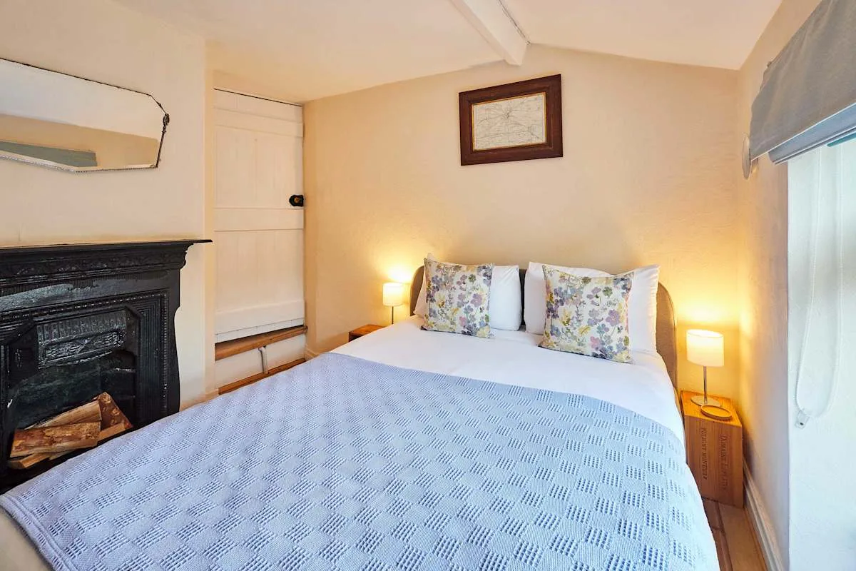A bedroom with a bed, patterned pillows, and bedside lamps.