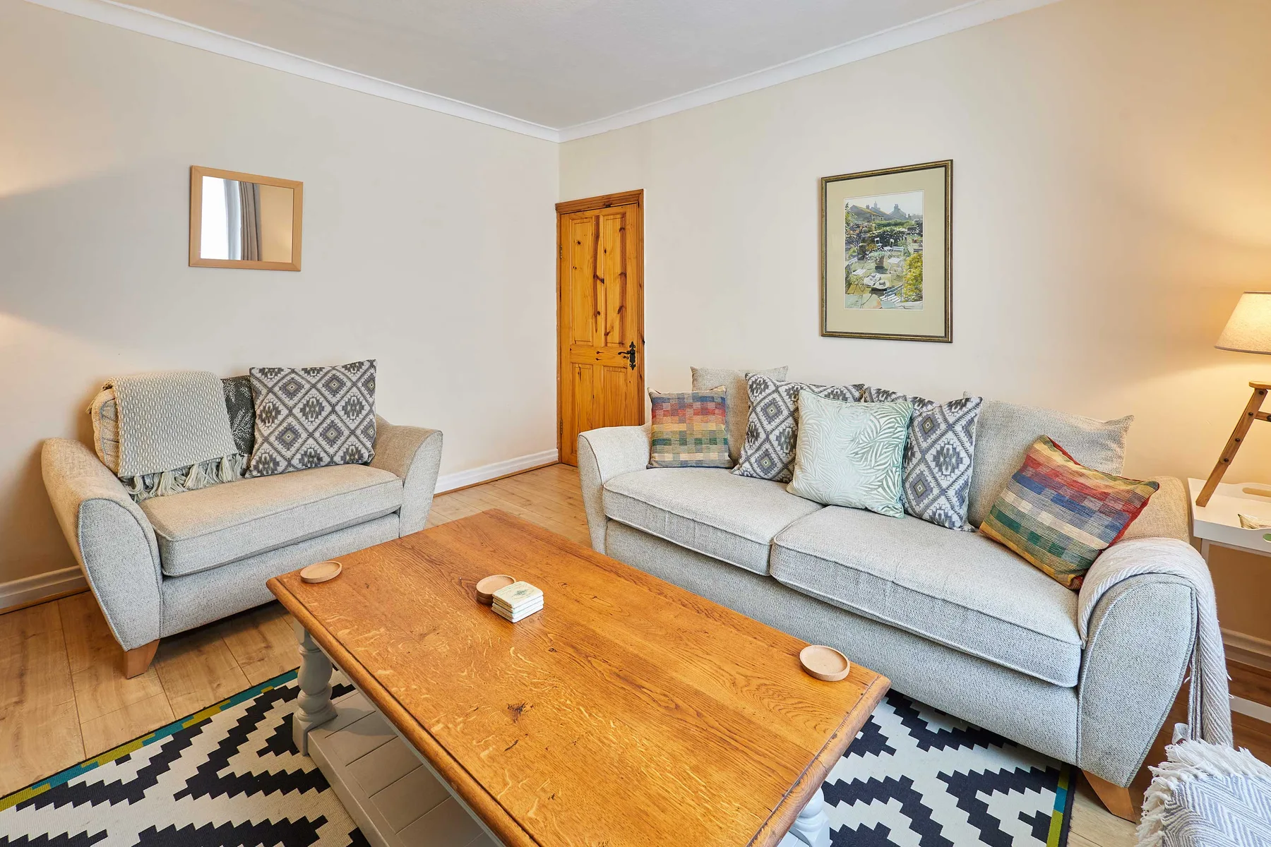A living room with light-colored seating around a wooden coffee table.