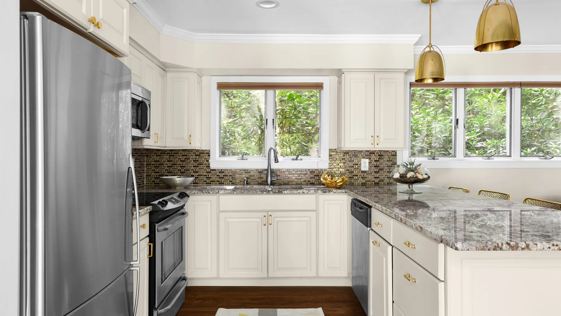 A bright kitchen with white cabinetry, a central sink, and a long island.