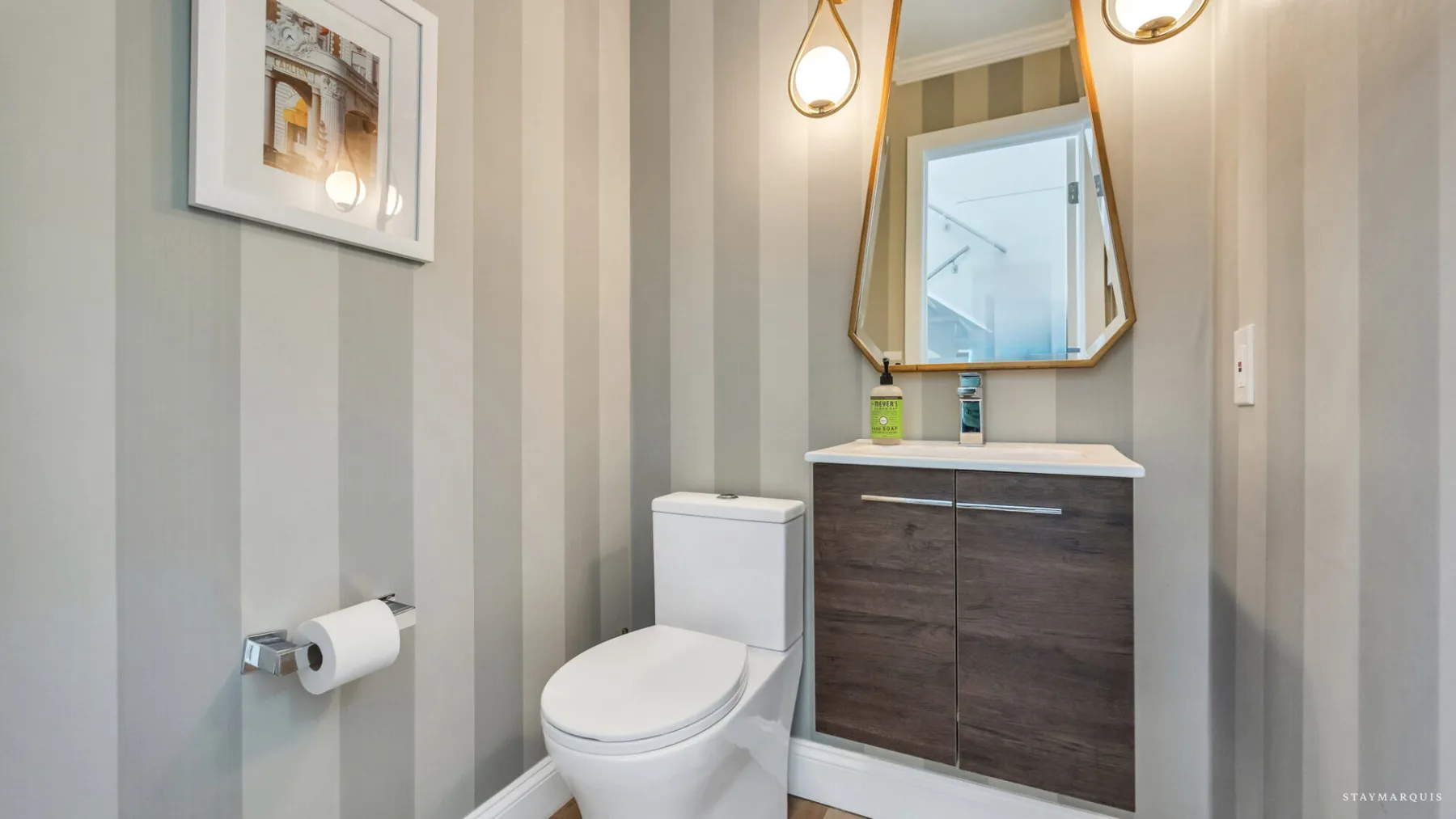 A bathroom with a toilet, vanity, and mirror.