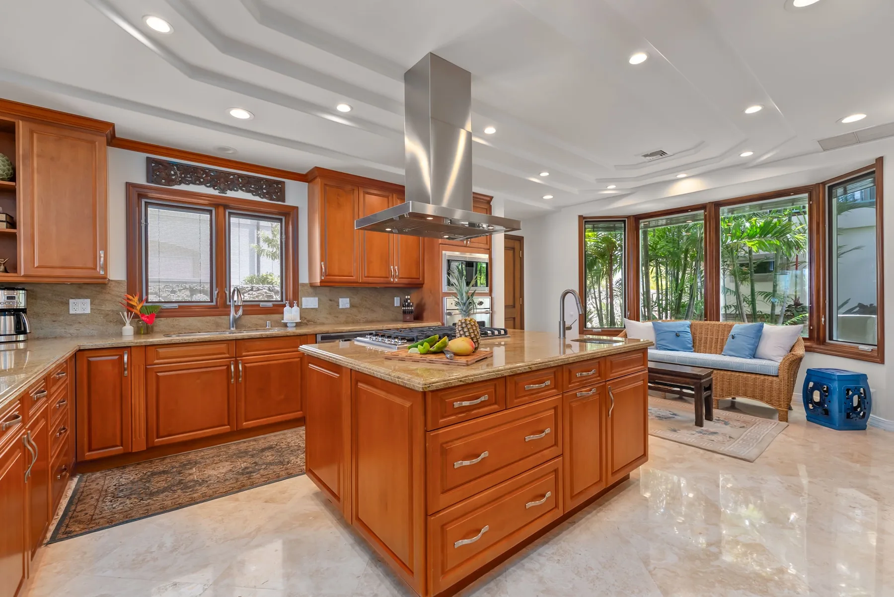 Una cocina amplia con gabinetes de madera y una isla central junto a una zona de estar.