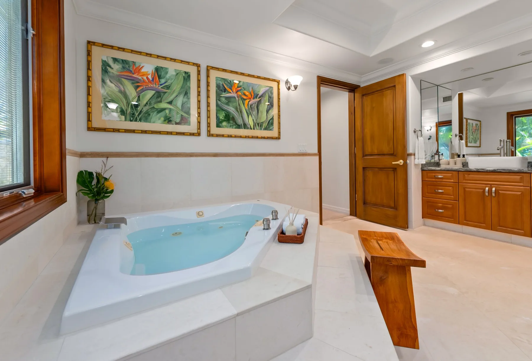 Un baño con una bañera empotrada y un tocador de madera.
