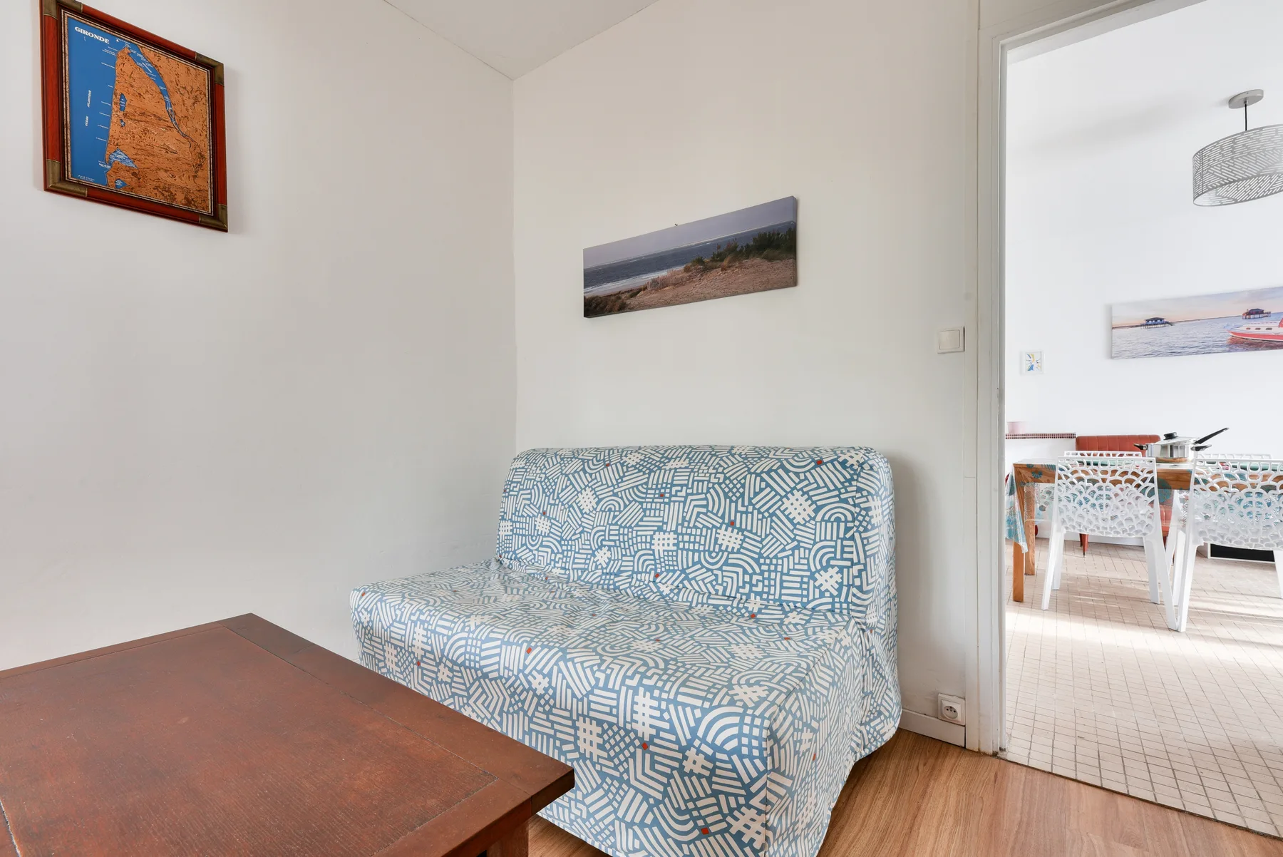 A living room with patterned seating and an open view into the dining area.
