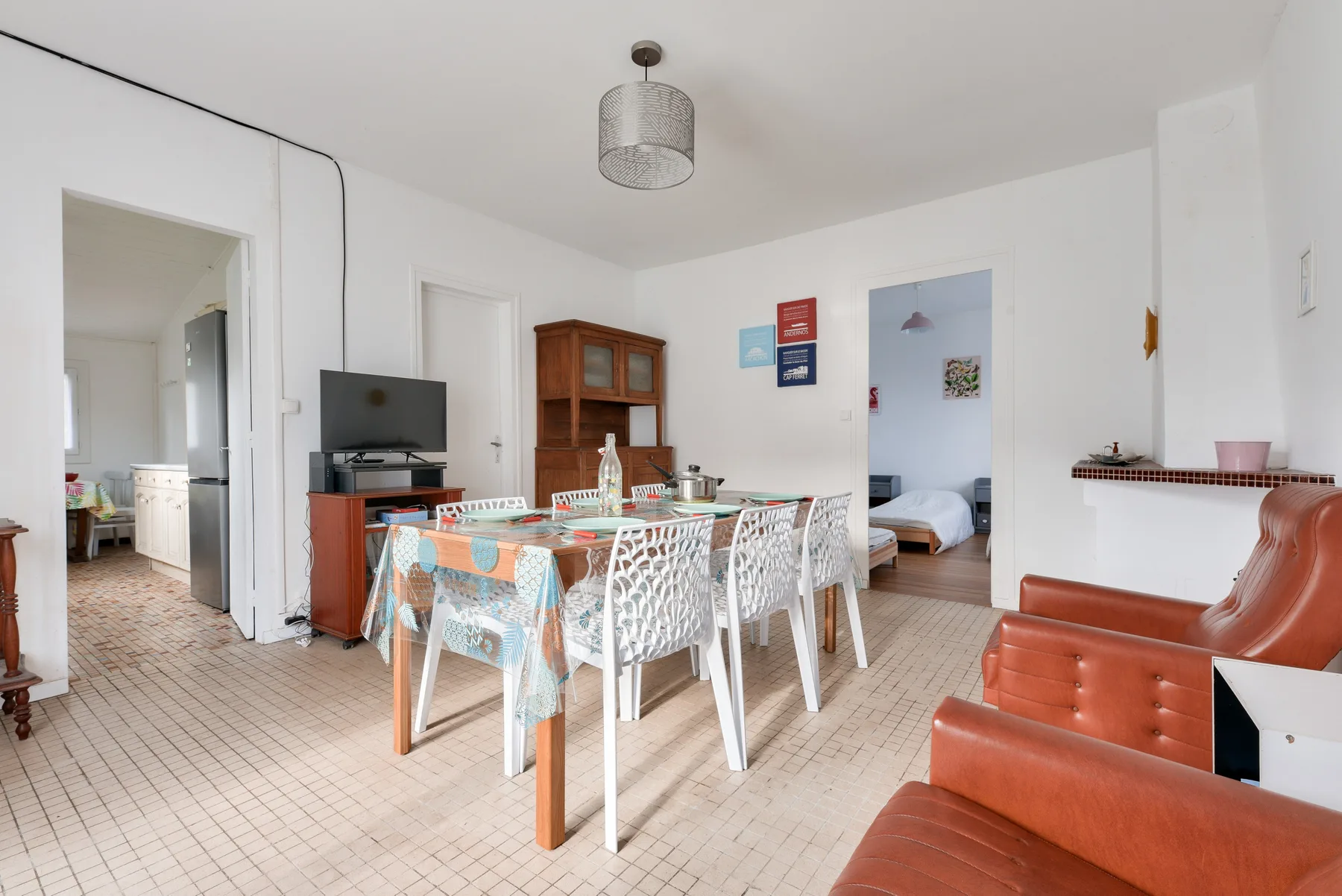A dining area with a table and chairs beside a living area.