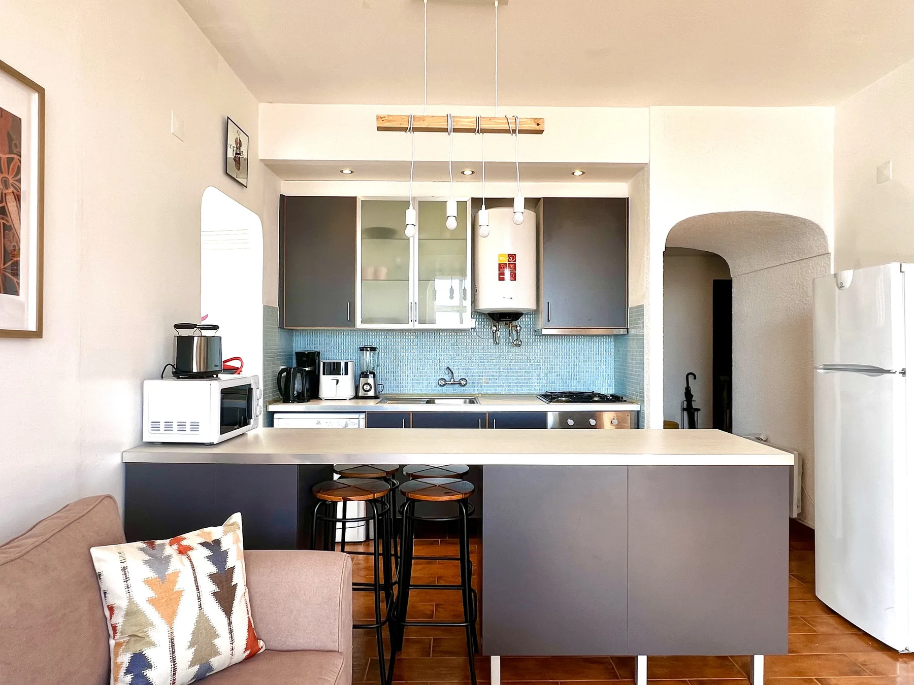 Una cocina luminosa con una encimera amplia y asientos de barra.