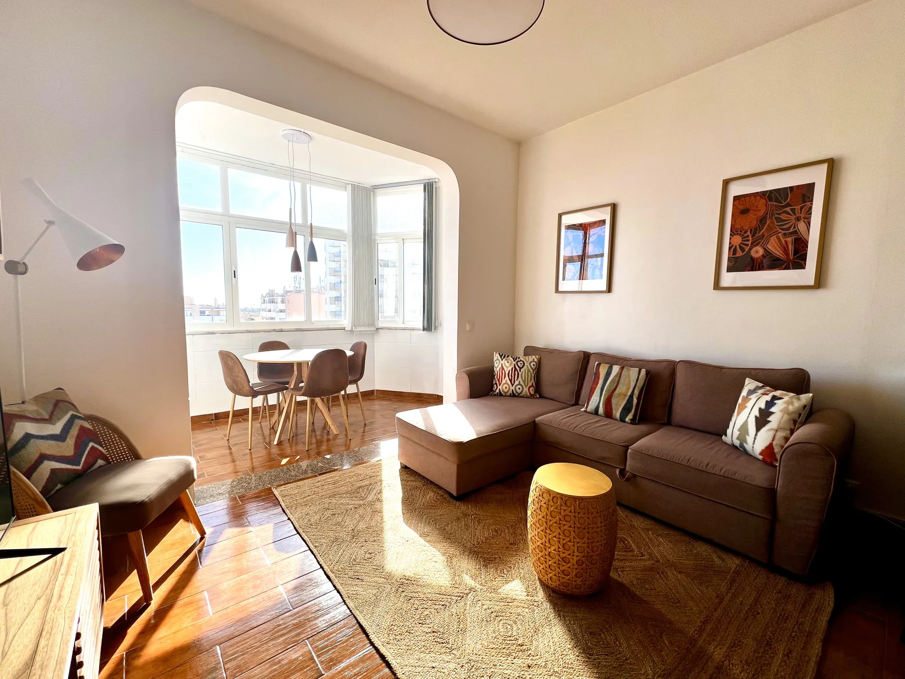 Una sala luminosa con un sofá seccional y un comedor contiguo.