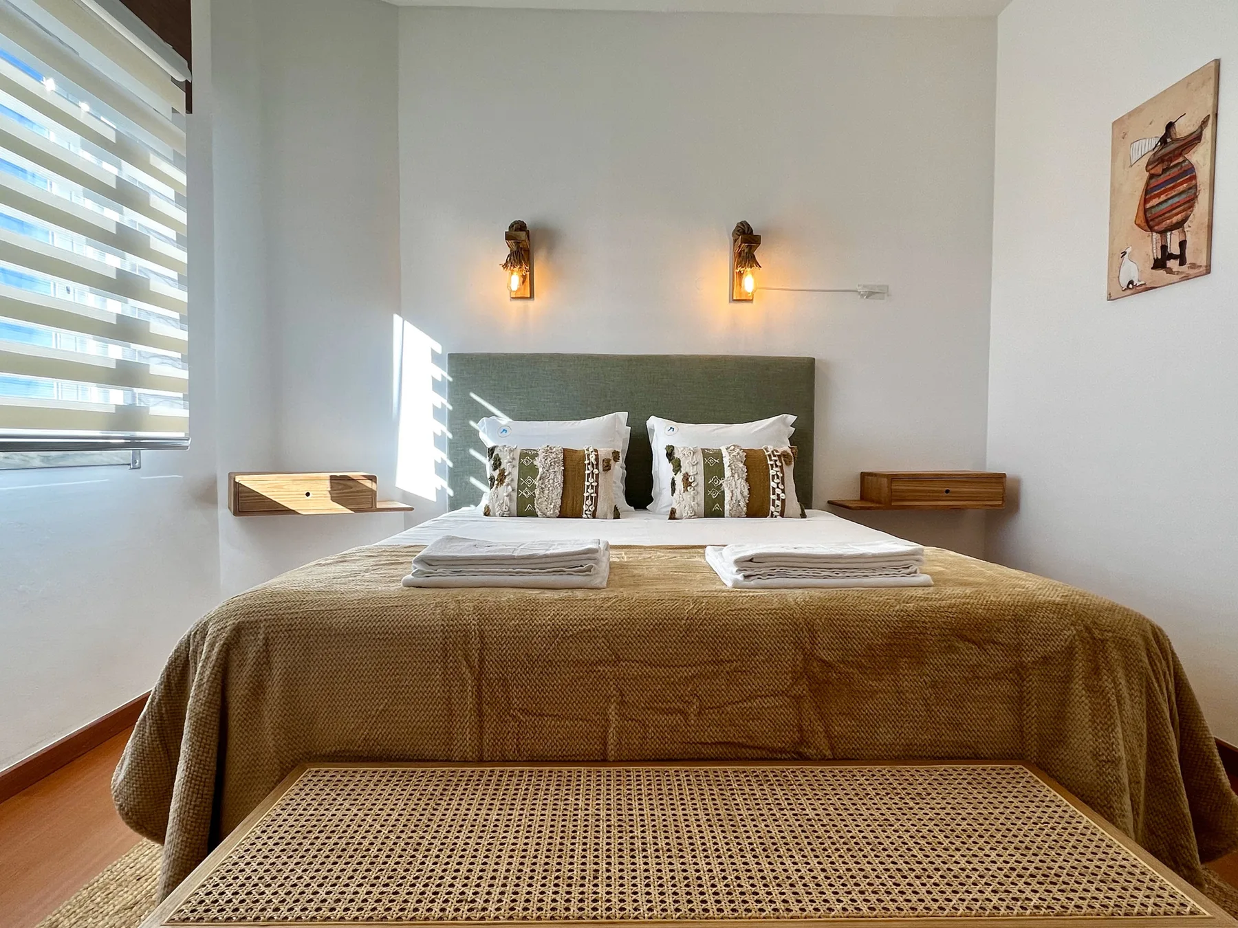 Un dormitorio con una cama bien hecha y luces junto a la cama.