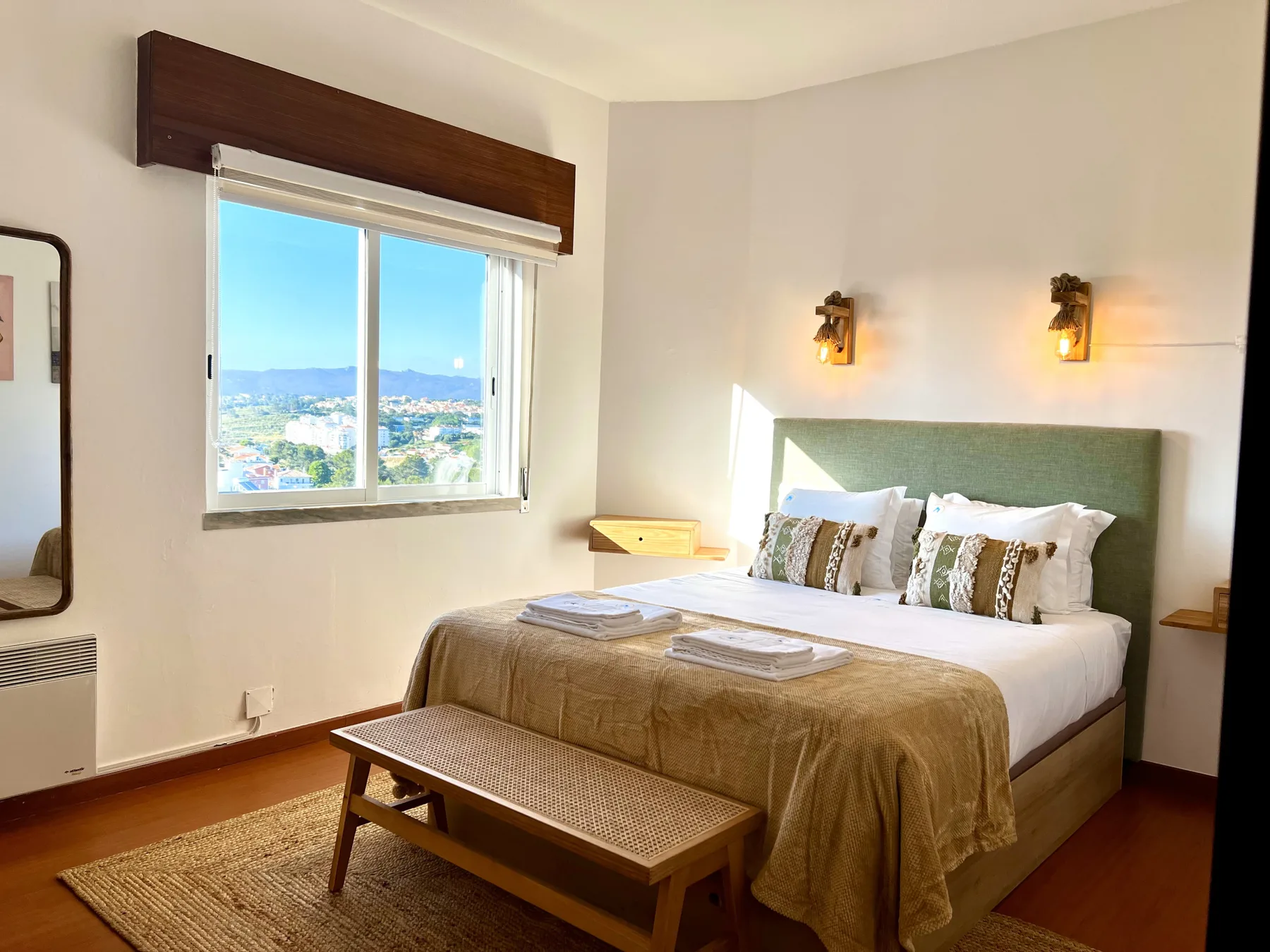 Un dormitorio con una cama bien hecha y una ventana con vistas al paisaje.