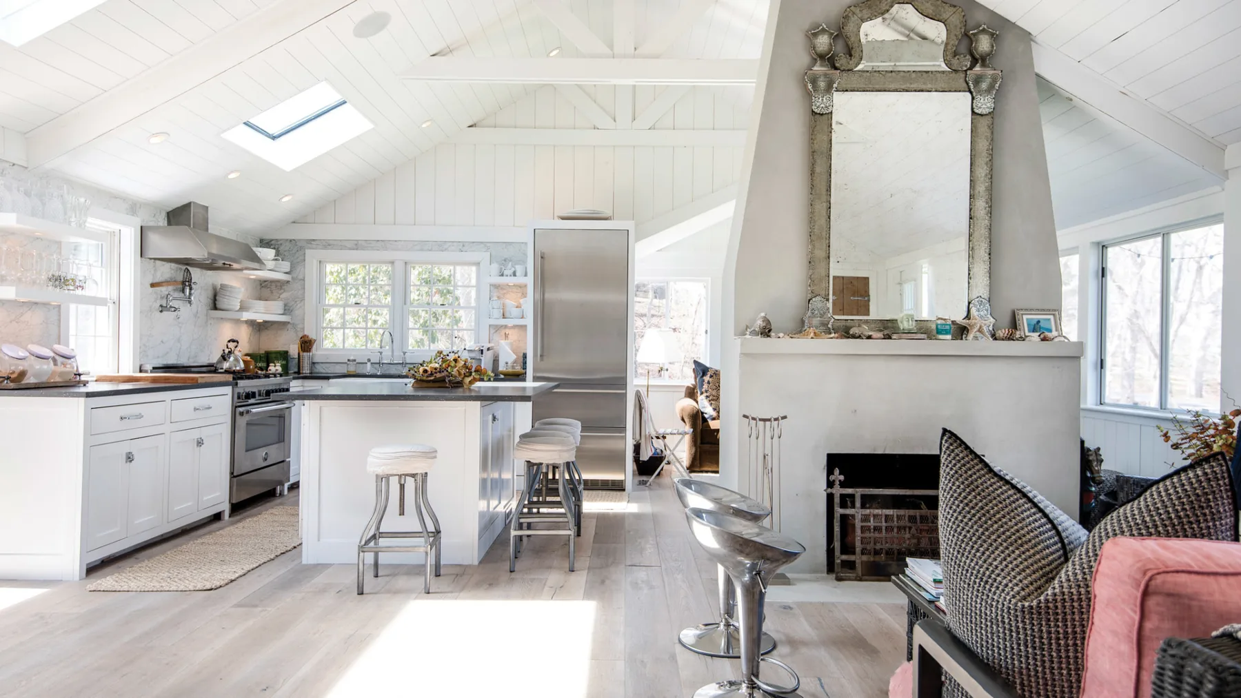 A bright open-plan kitchen and living area with a central island and fireplace.