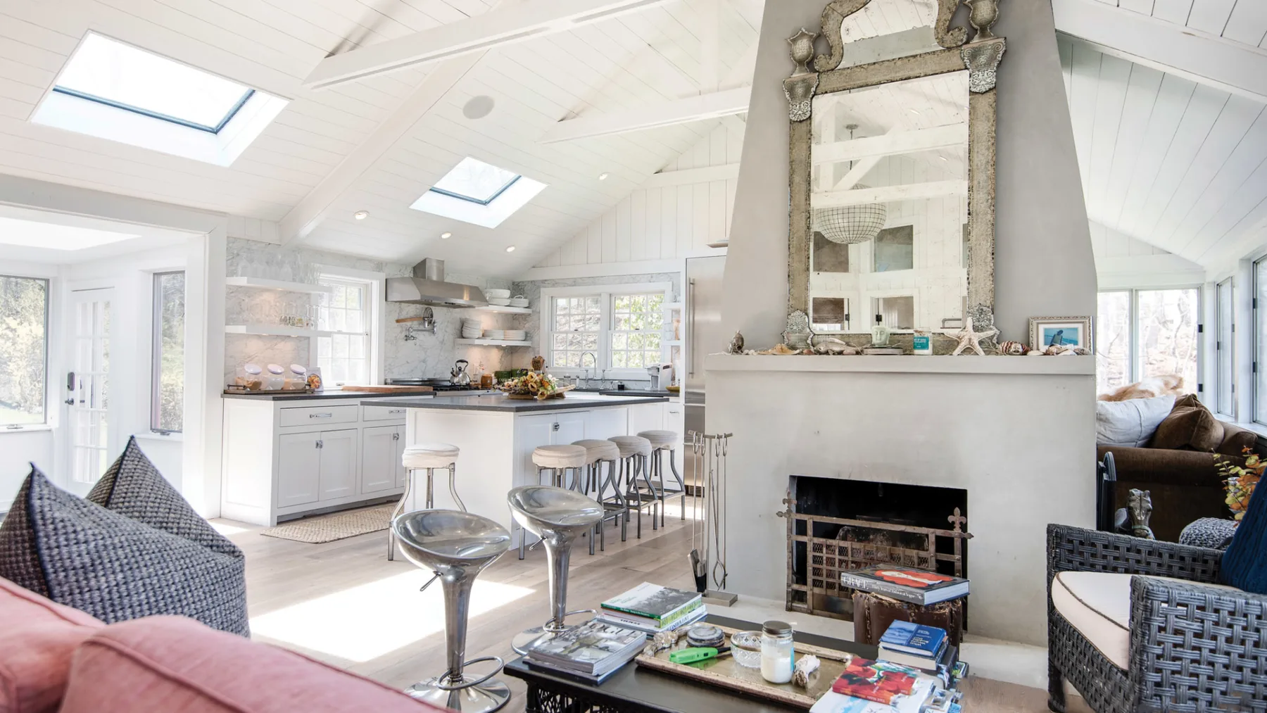 A bright open-plan kitchen and living area with a central fireplace.