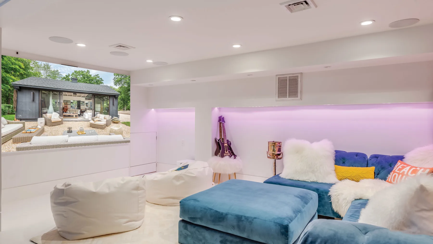 A bright lounge with blue seating and a large window overlooking a garden.