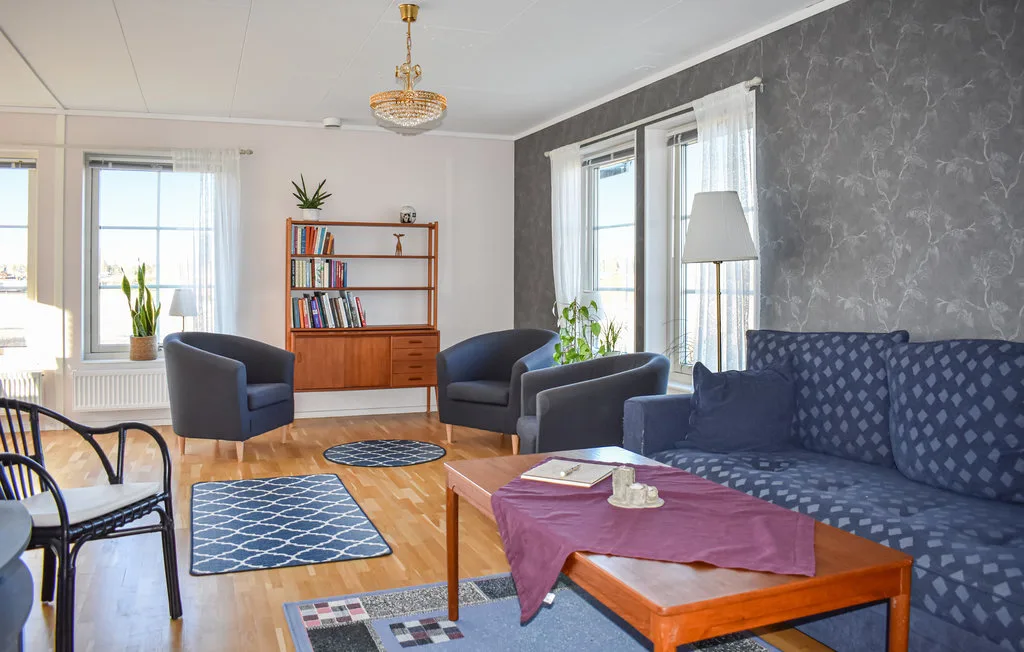 A living room with seating, a coffee table, and large windows.