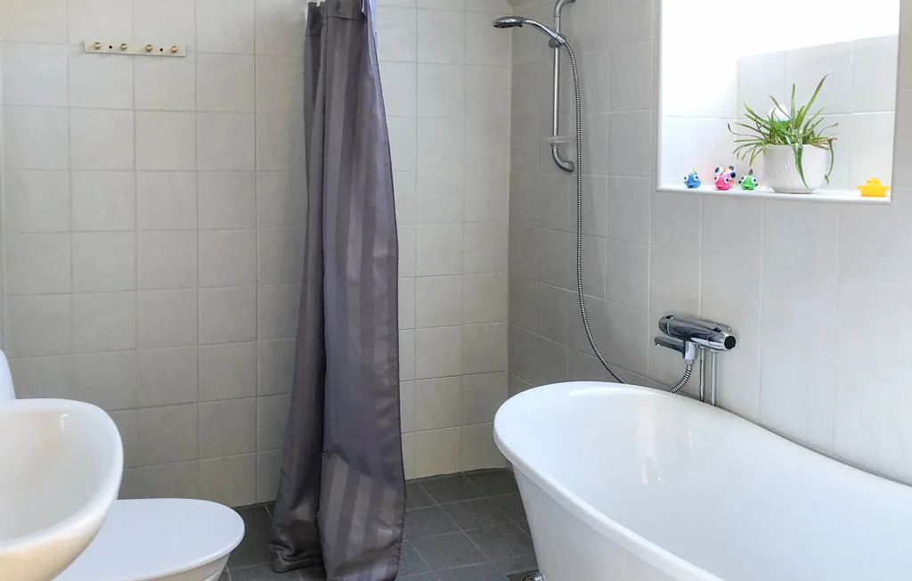 A tiled bathroom with a bathtub and shower.