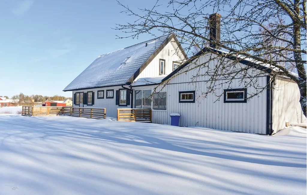 A white building stands in a snowy landscape beneath a clear sky.