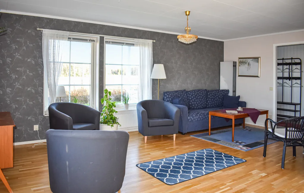 A living room with seating, a coffee table, and windows.