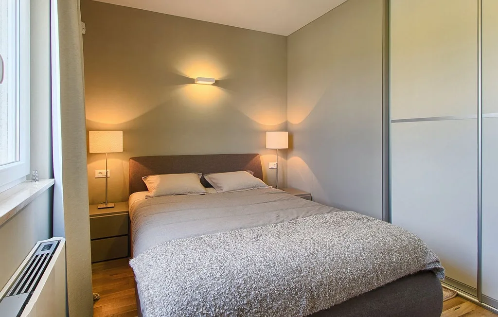 Un dormitorio con una cama tendida y lámparas de mesita.