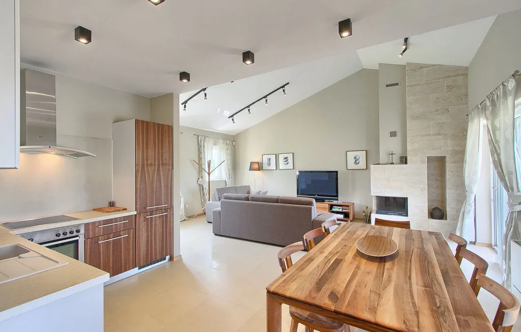 Una sala-comedor de concepto abierto con una mesa larga de madera y asientos.