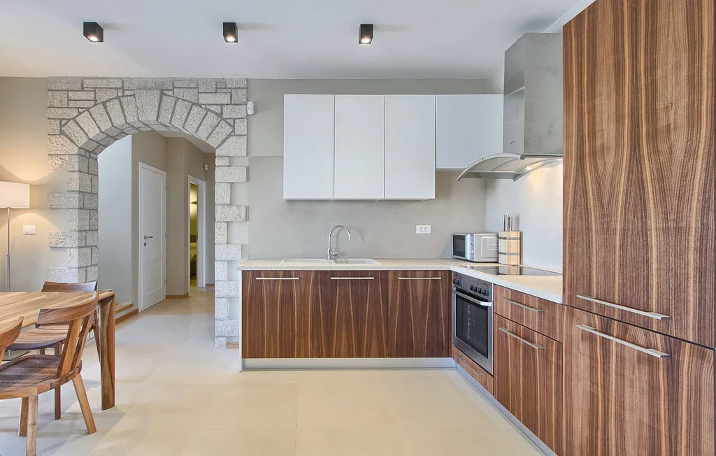 Una cocina abierta con zona de comedor, muebles de madera y una mesa.