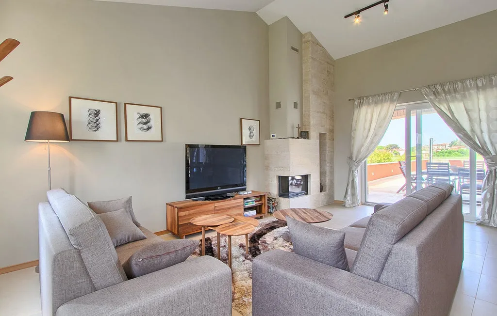 Una sala de estar con asientos alrededor de un televisor y una chimenea.