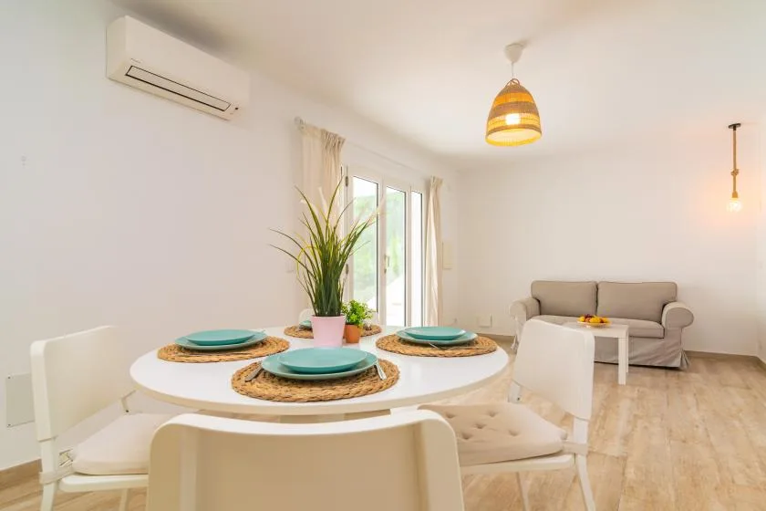 A bright dining area with a round table and a seating area in the background.