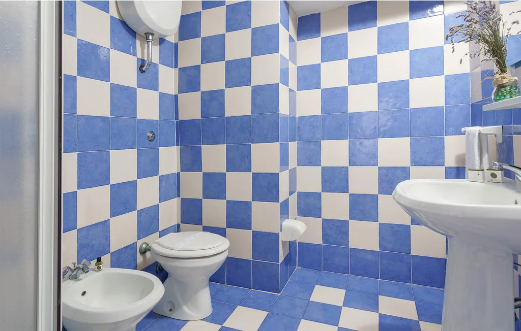 A bathroom with blue-and-white checkerboard tiles and a sink.