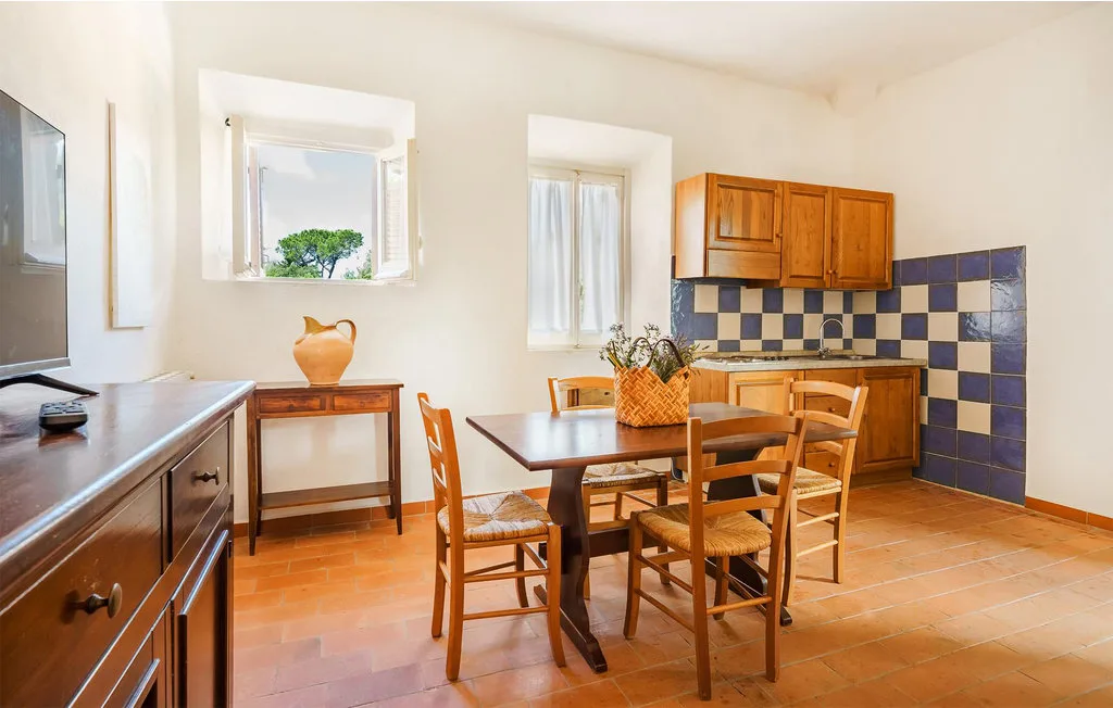 A dining area with wooden seating and a compact kitchen along the back wall.