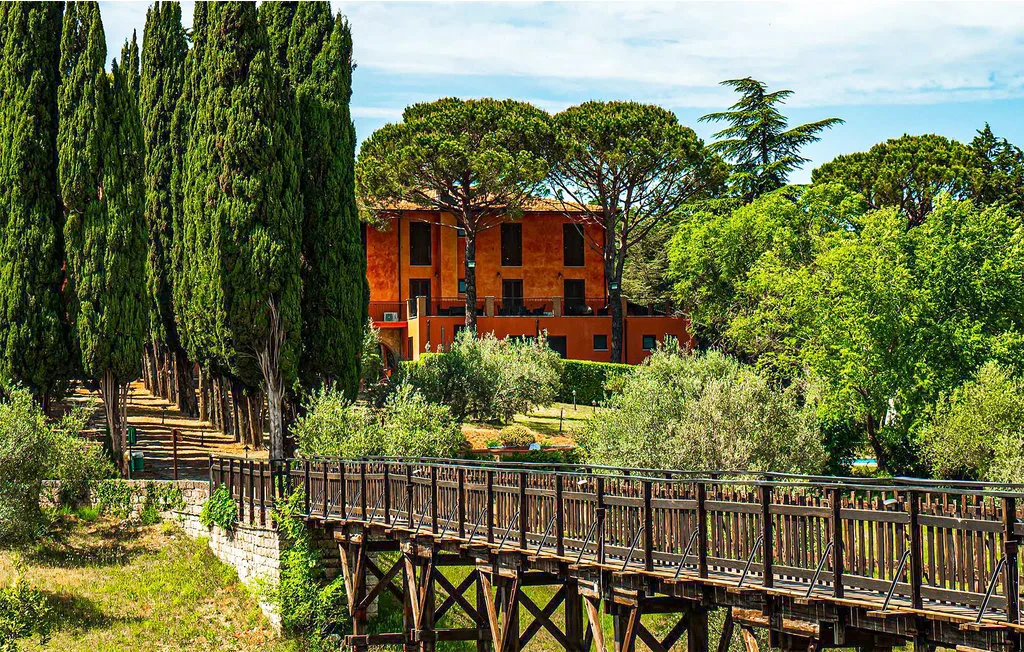 An orange building stands among trees beside a raised wooden walkway.