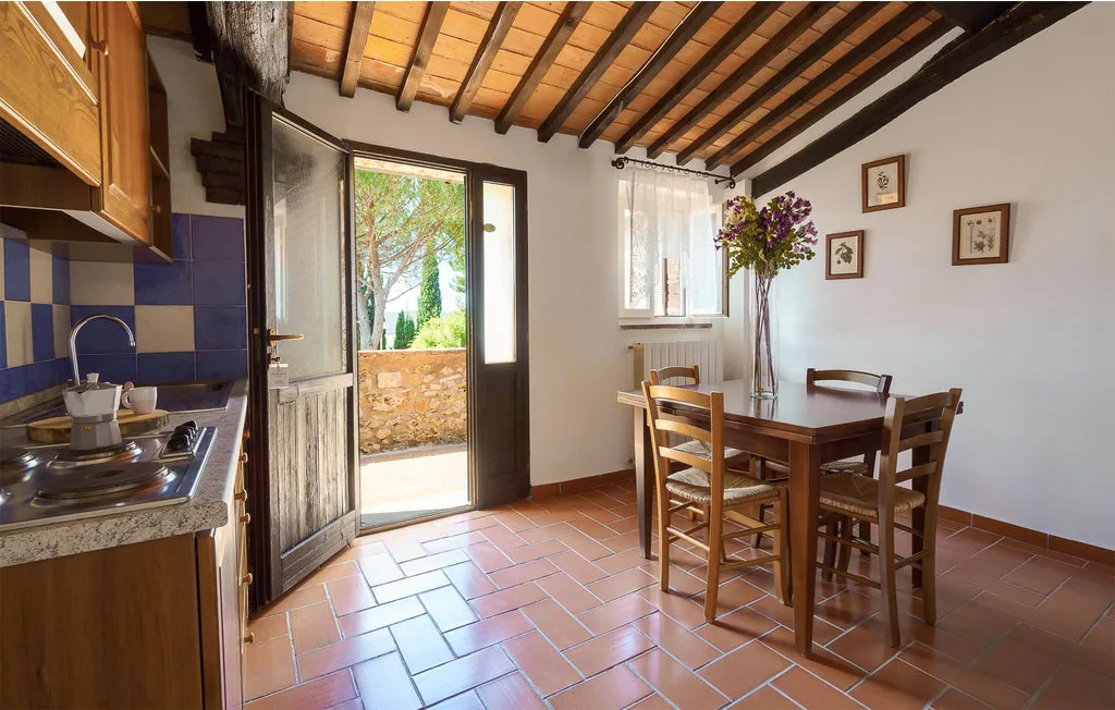 A dining area with a wooden table and chairs beside a compact kitchen.