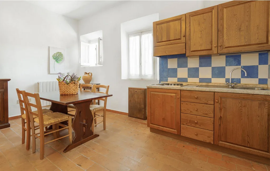 A kitchen with wooden cabinets, a tiled backsplash, and a dining table.