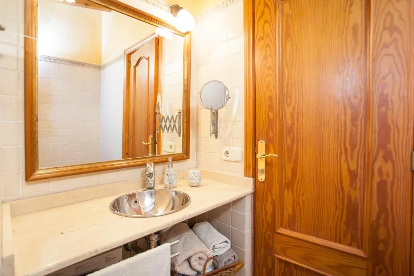 A bathroom vanity with a sink, mirror, and wooden door.