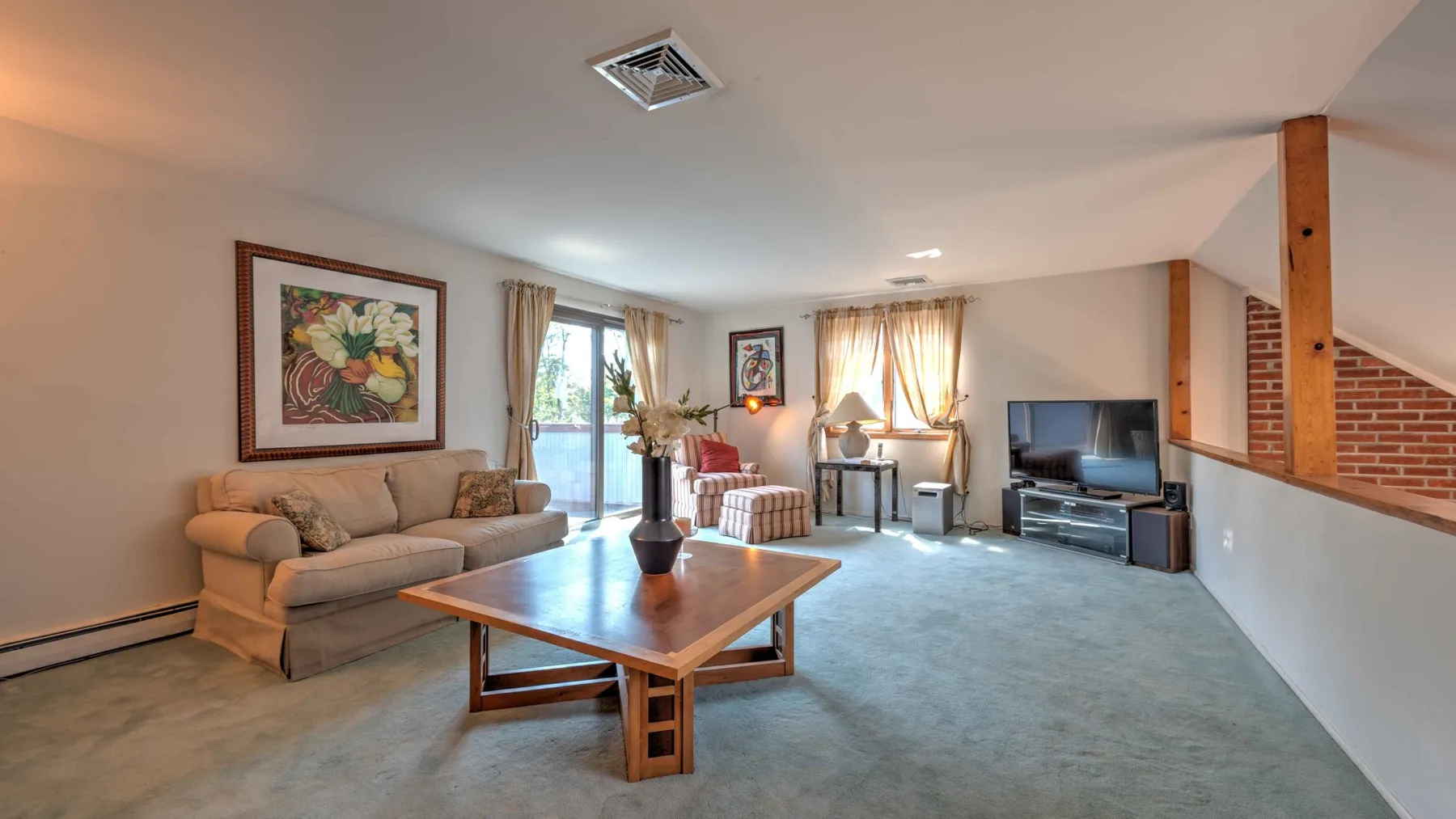 A living room with seating, a coffee table, and a television.