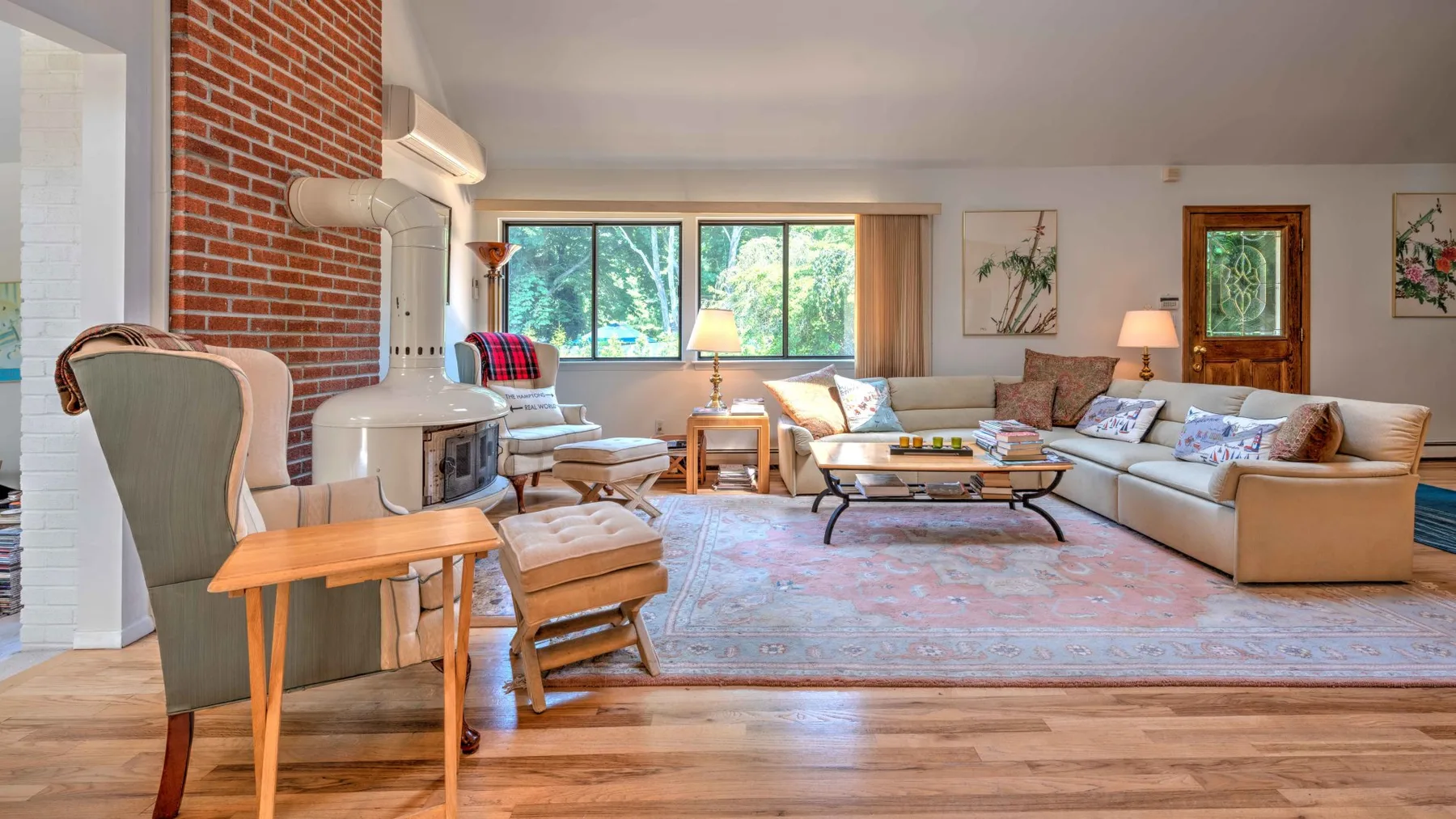 A living room with seating arranged around a coffee table and a large rug.